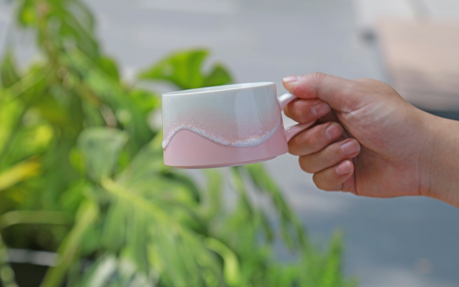Hand holds a pink and white gradient wavy cup