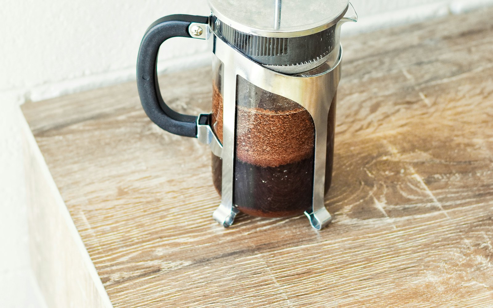 A french press coffee maker on a wooden table