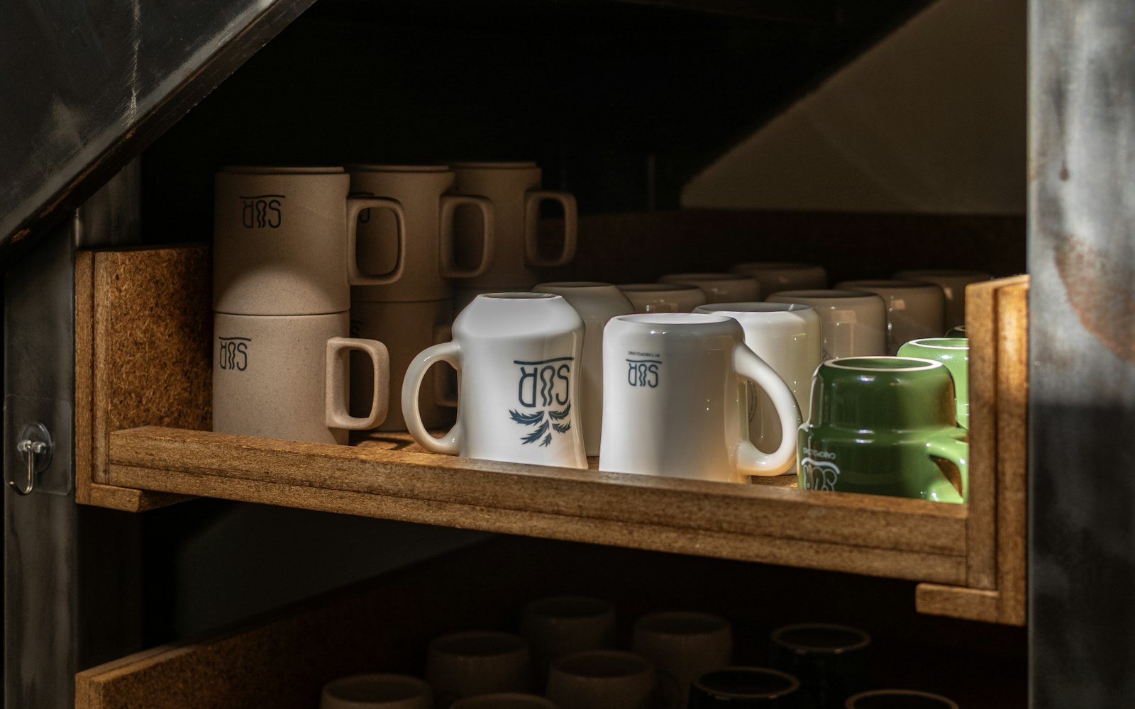 Various mugs and cups neatly arranged on shelves