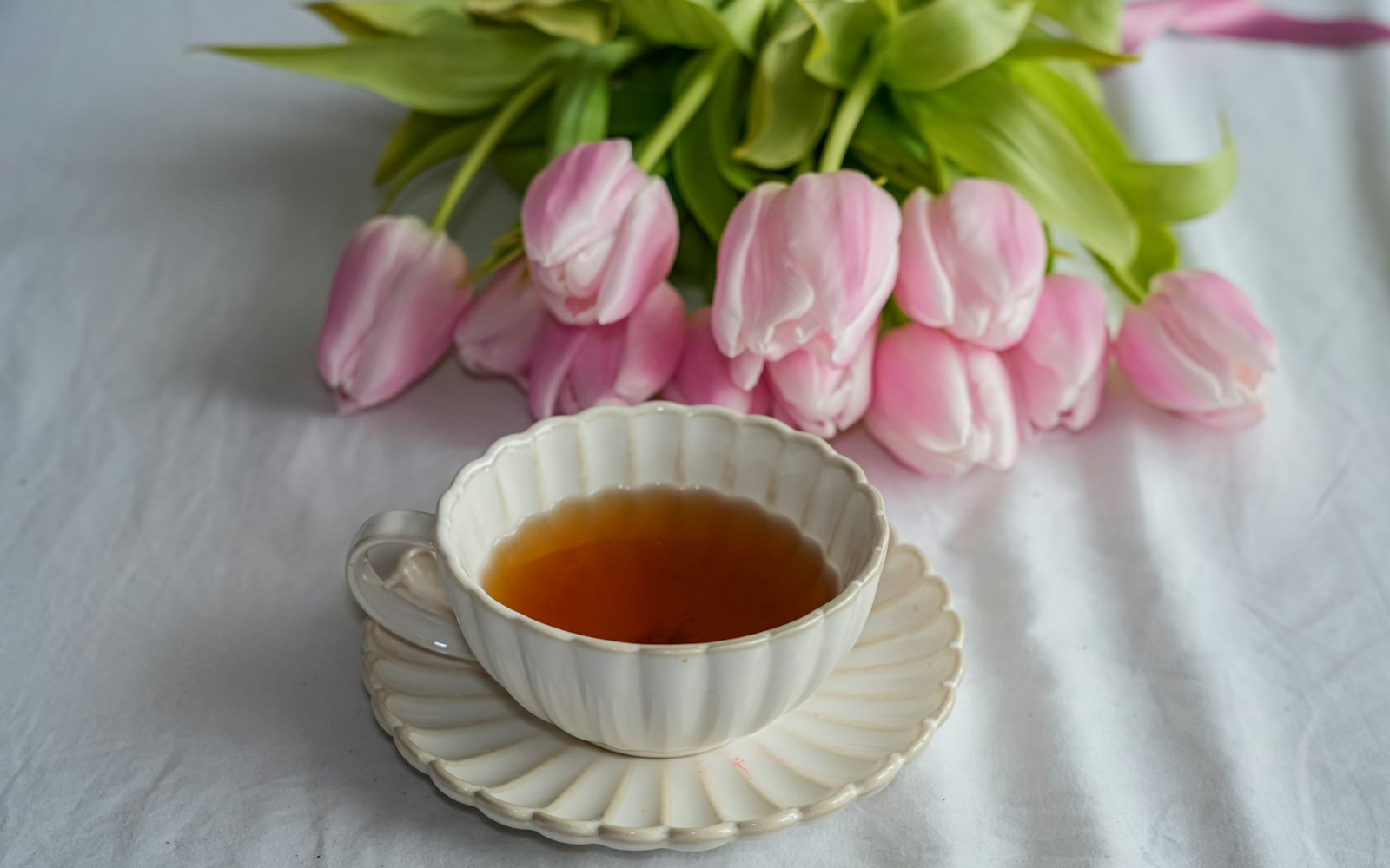 A cup of tea with pink tulips