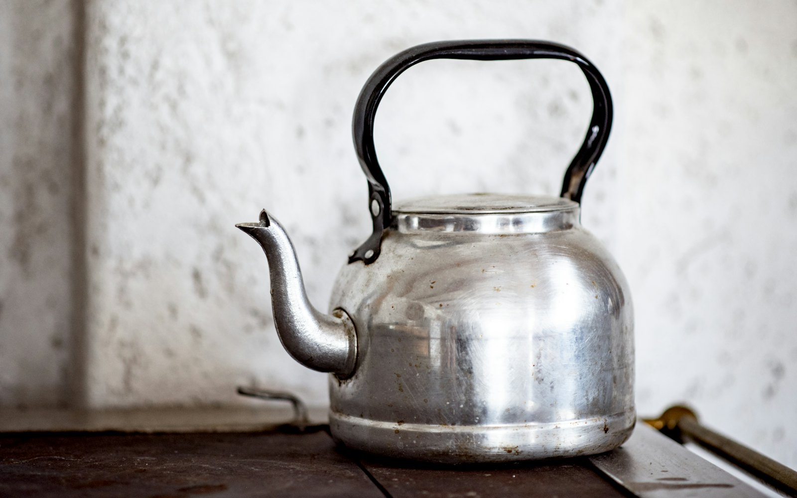 Stainless steel kettle on brown wooden table